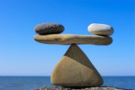 Balanced rocks on a blue sky background to represent gaining life balance through work with Psychic Elaine Palmer.