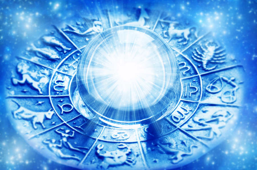 Astrology signs on wheel with crystal ball in the center. Composed with a blue filter.